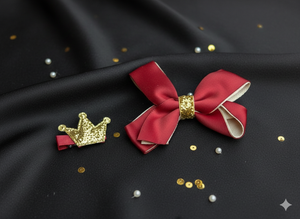 Red bow with gold center and gold crown on black fabric with gold and silver sequins