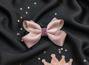 Pink bow with a glittery center on black fabric with decorative elements