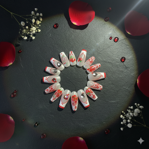 Decorative nail art designs arranged in a circular pattern on a dark surface with red petals and small flowers.