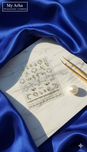 Aesthetic gold celestial nail art stickers featuring moon, stars, and planet designs on a white marble background with blue silk drapes, pearl, and gold tweezers — My Arha Premium DIY Art.