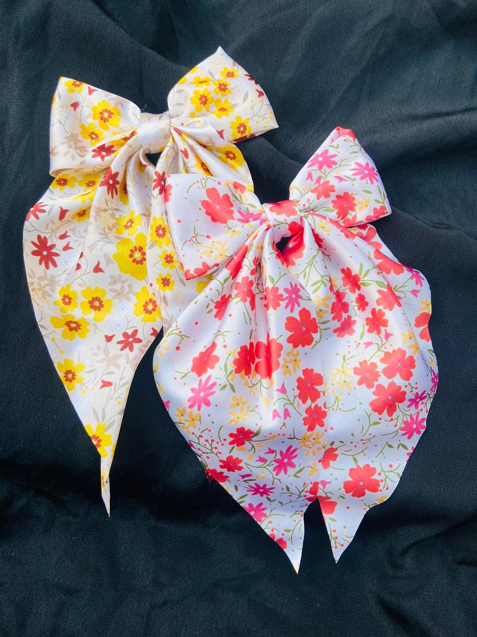 Two floral fabric bows on a black background