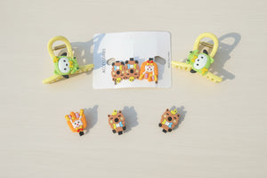 Colorful animal-themed hair clips on a black background