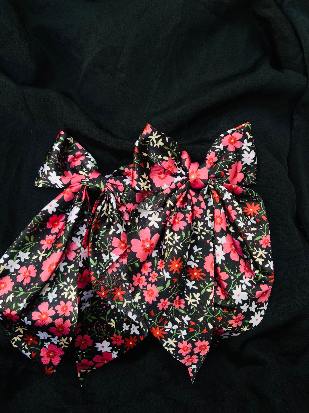 Floral patterned fabric with pink and white flowers on a black background