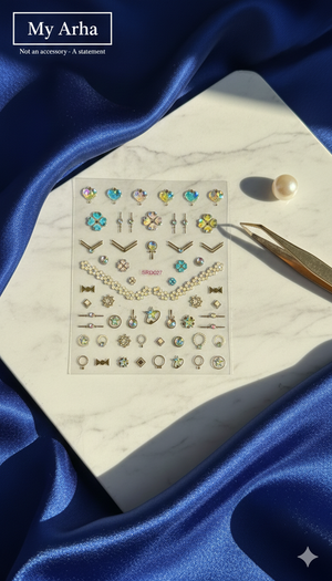 Premium holographic and gold rhinestone nail art stickers on a white marble display with royal blue silk, luxury pearl, and gold tweezers — My Arha Professional DIY Nail Art.