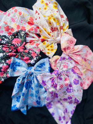 Collection of floral-patterned hair bows on a black background