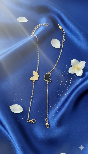 Gold necklace with clover pendants on a blue satin background with white flowers.