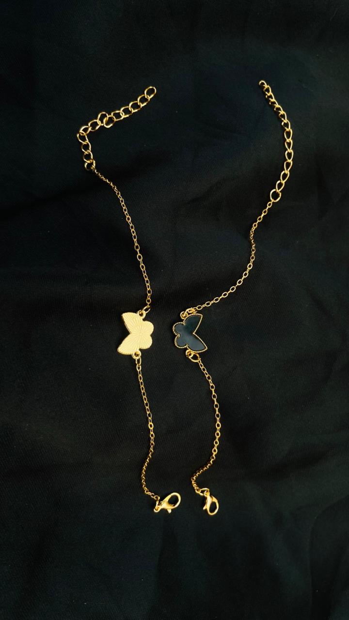 Gold butterfly necklace on a dark fabric background