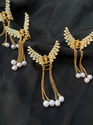 Gold necklaces with pearl pendants on a black fabric background